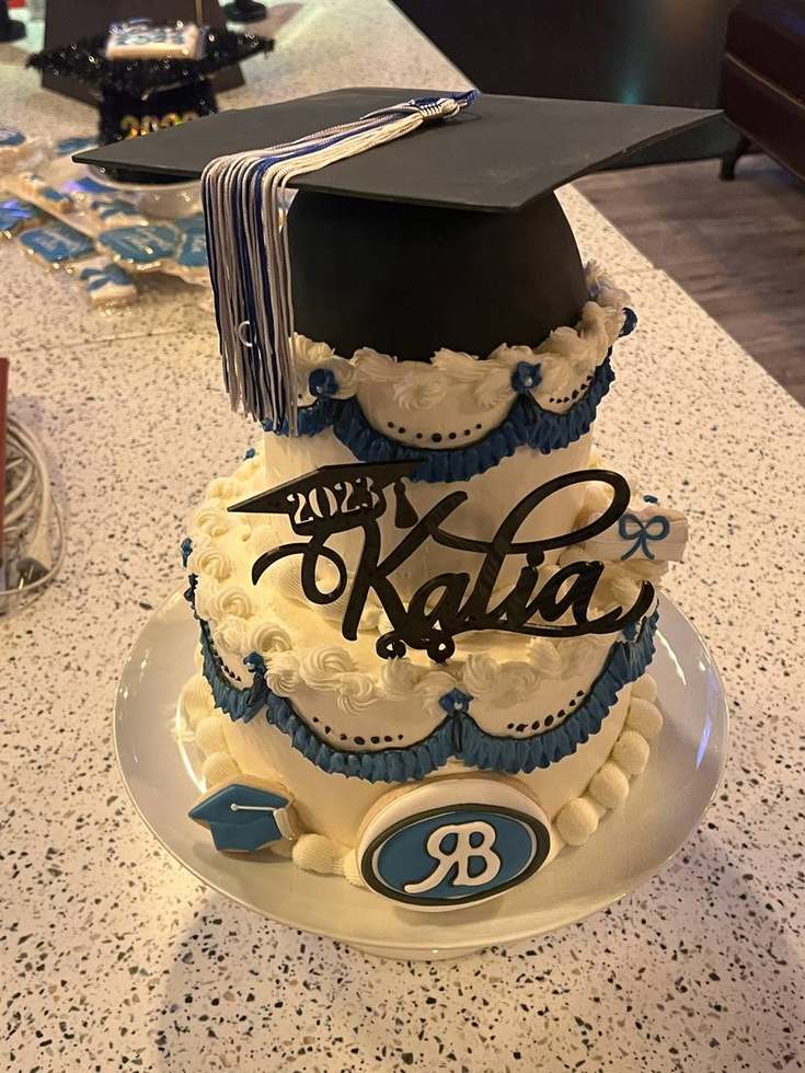 Blue and white graduation cake with tassel cap topper