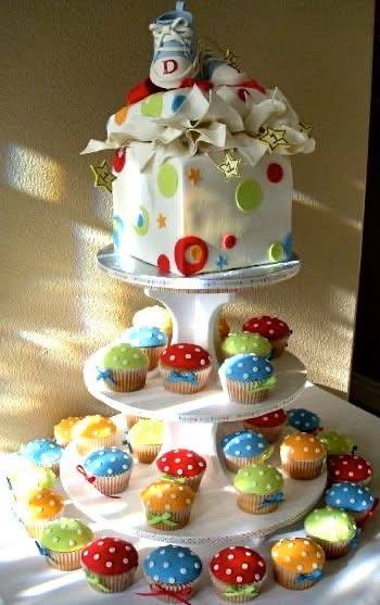 Polka dot baby shower cake topped with a sculpted baby shoe, on a cupcake tower