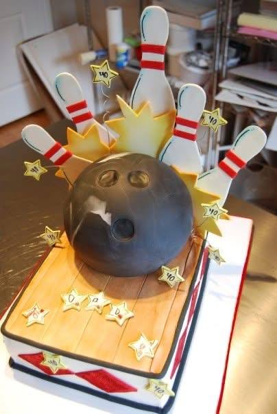 Bowling cake with a sculpted ball crashing into pins