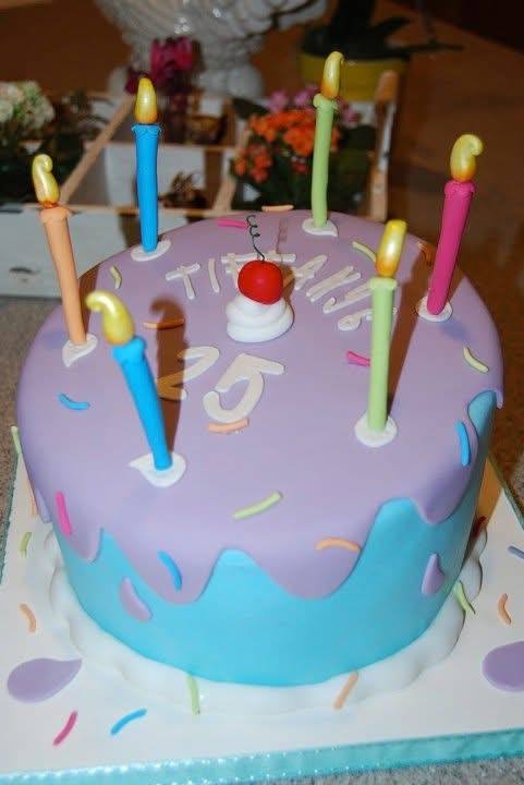 Purple and blue drip birthday cake with sculpted candles and sprinkles