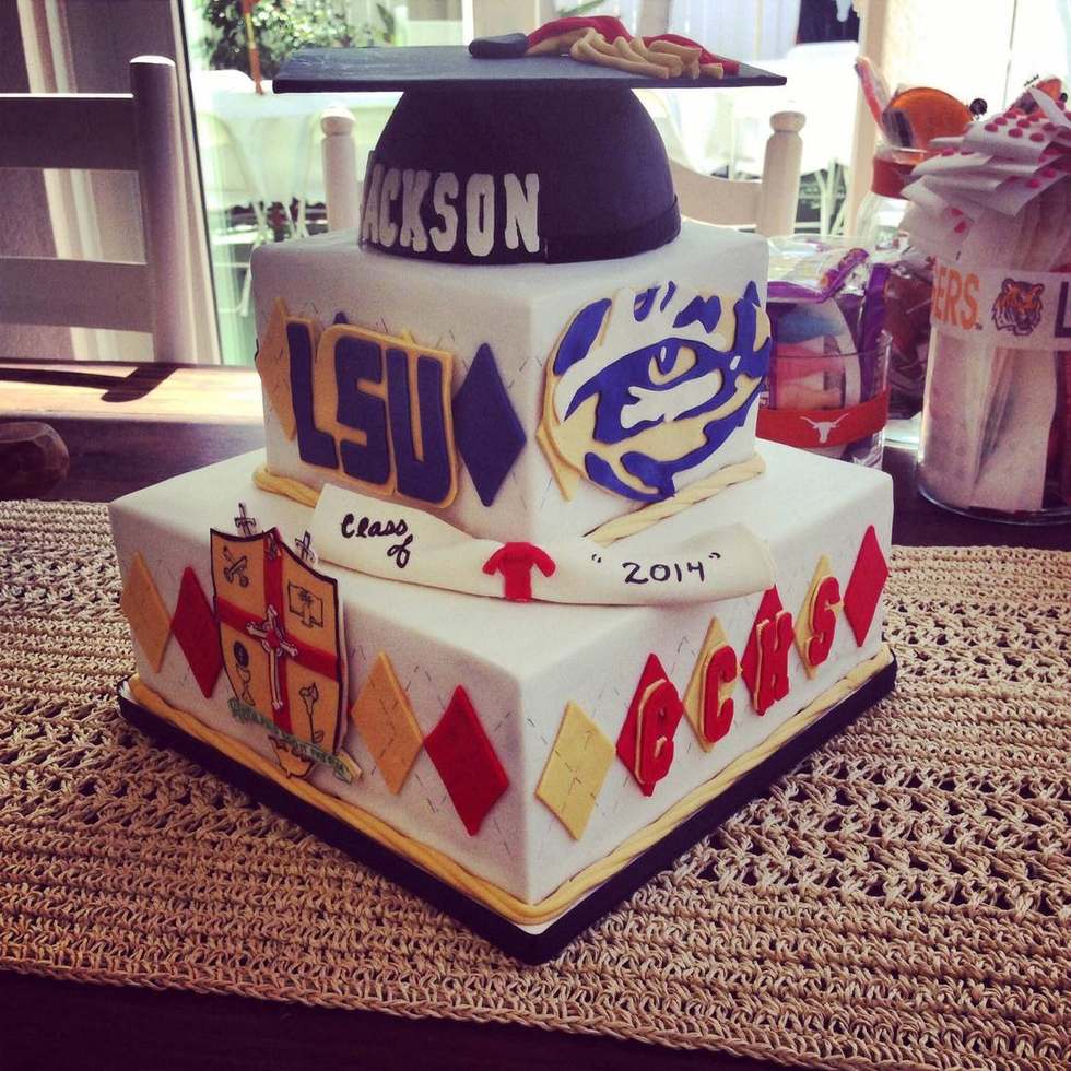 Two tier graduation cake with school crest, LSU logo and a personalized cap topper