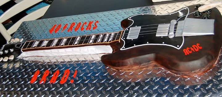 Sculpted electric guitar cake on a diamond plate board