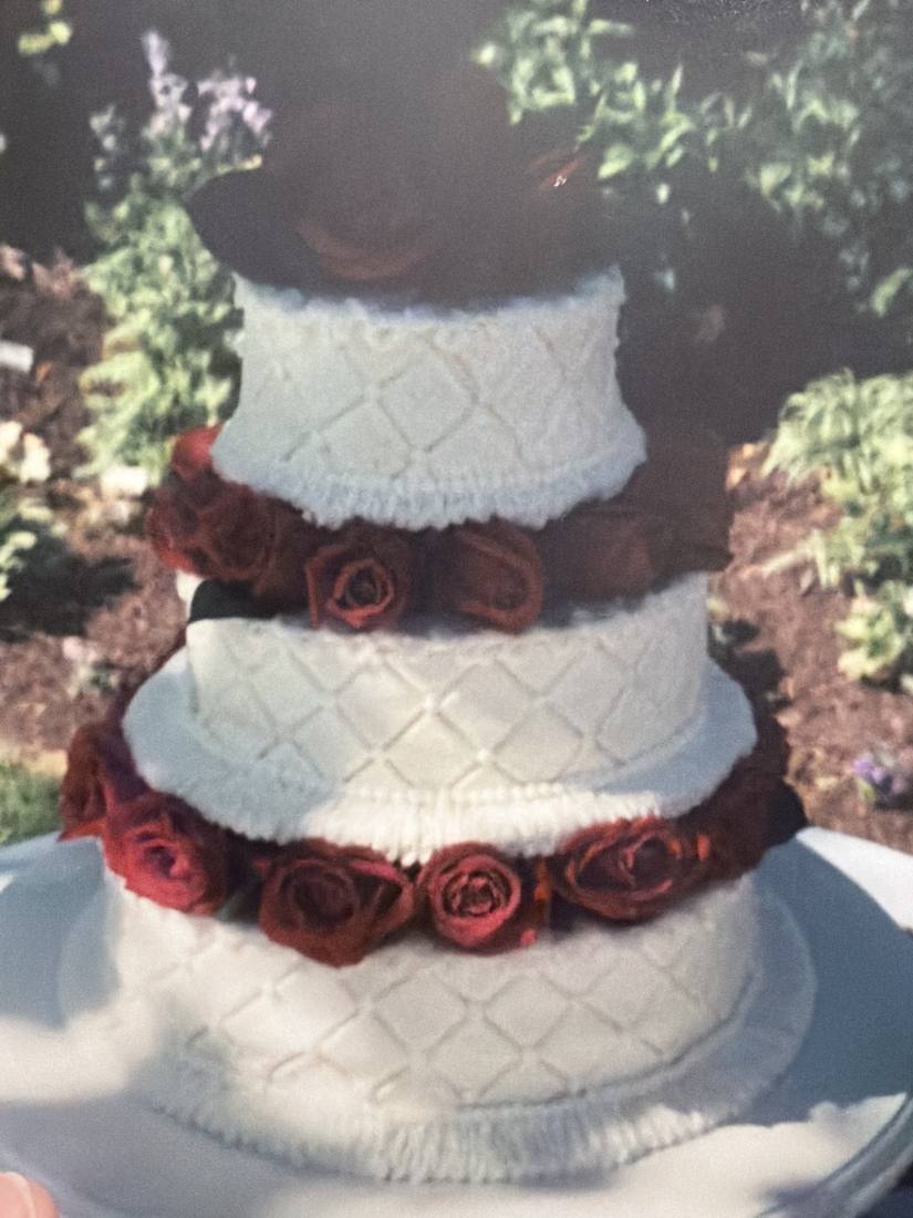 Classic white tiered wedding cake with dark red roses